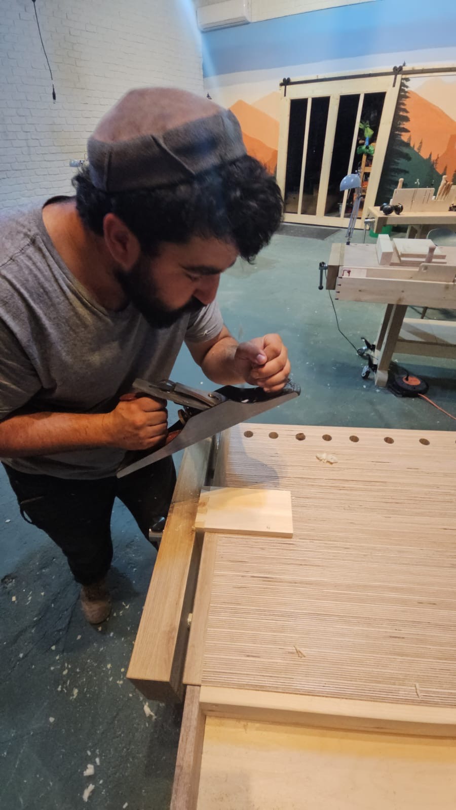 Man carving wood at workbench