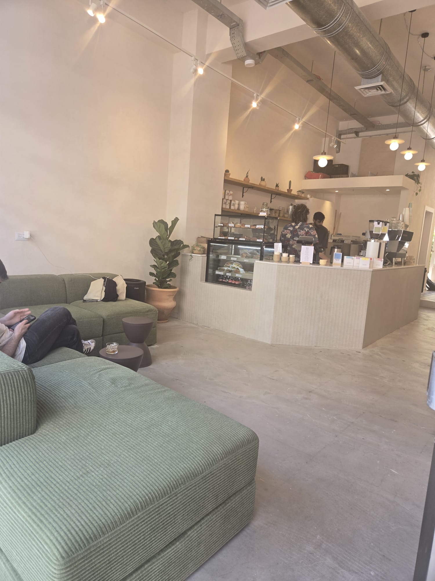 Cafe Maagan interior with green sofas and the coffee bar