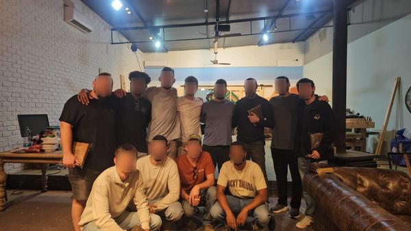 Group of participants posing in the indoor wood workshop